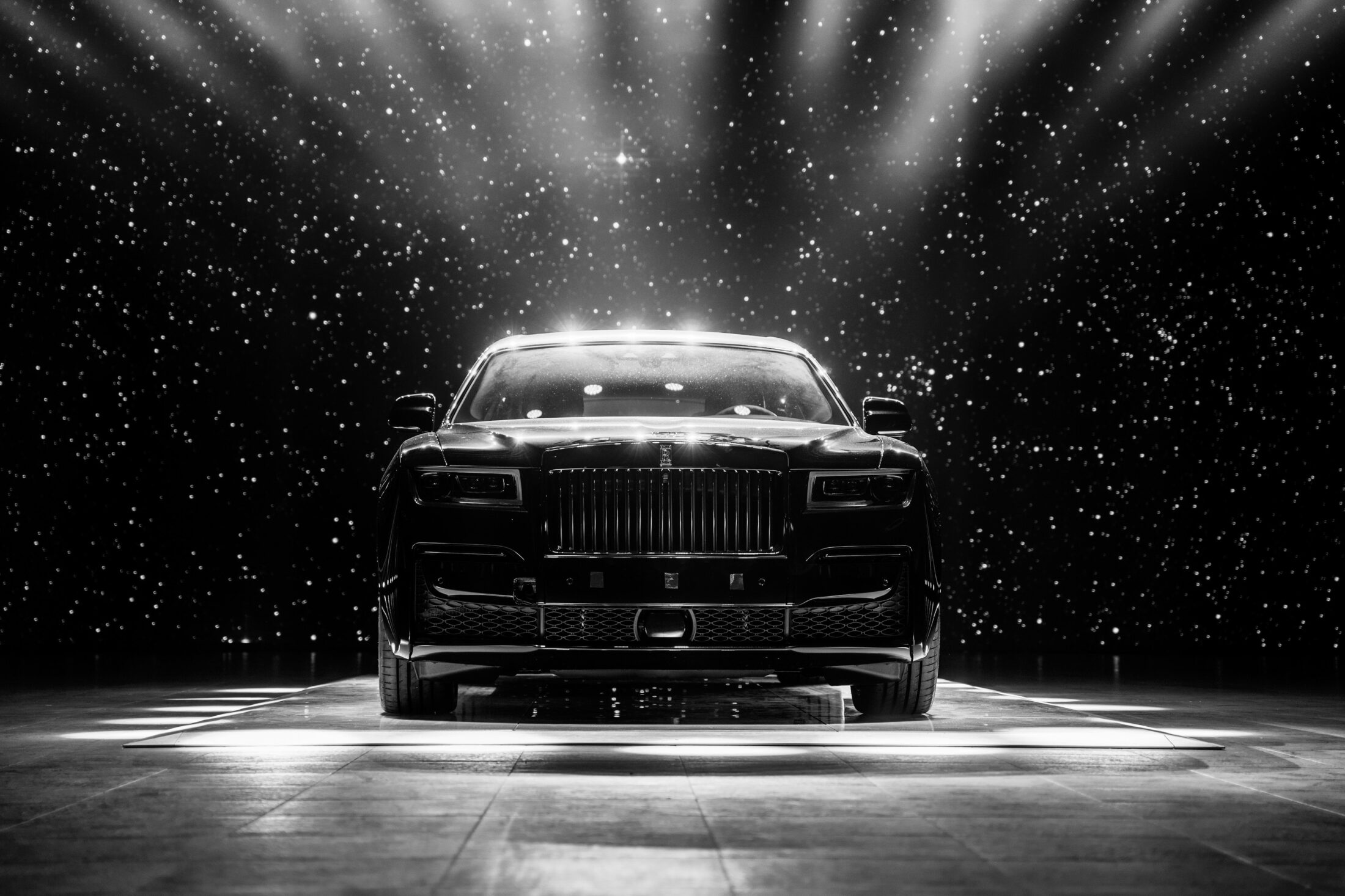 Rolls-Royce Cullinan Black Badge sous un ciel étoilé, photographie en noir et blanc