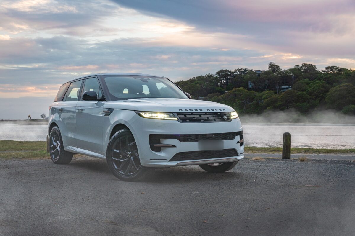 Range Rover Sport blanc au bord de l’eau au lever du soleil
