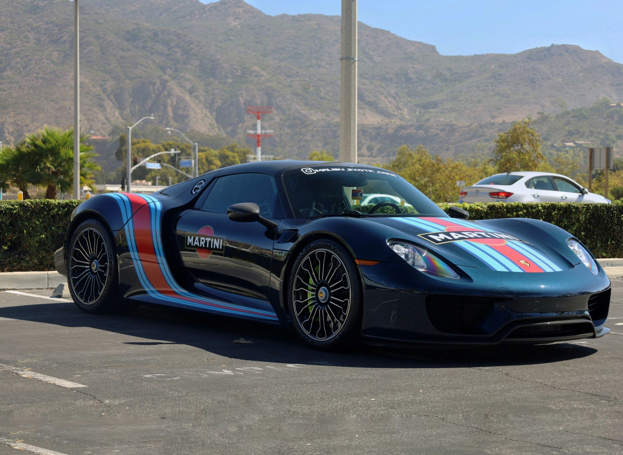 Porsche 918 Spyder en livrée Martini sur un parking