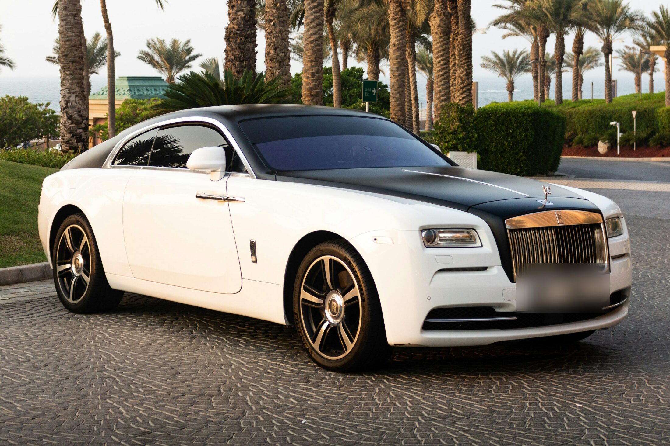 Rolls-Royce Wraith bicolore blanc et noir sous les palmiers