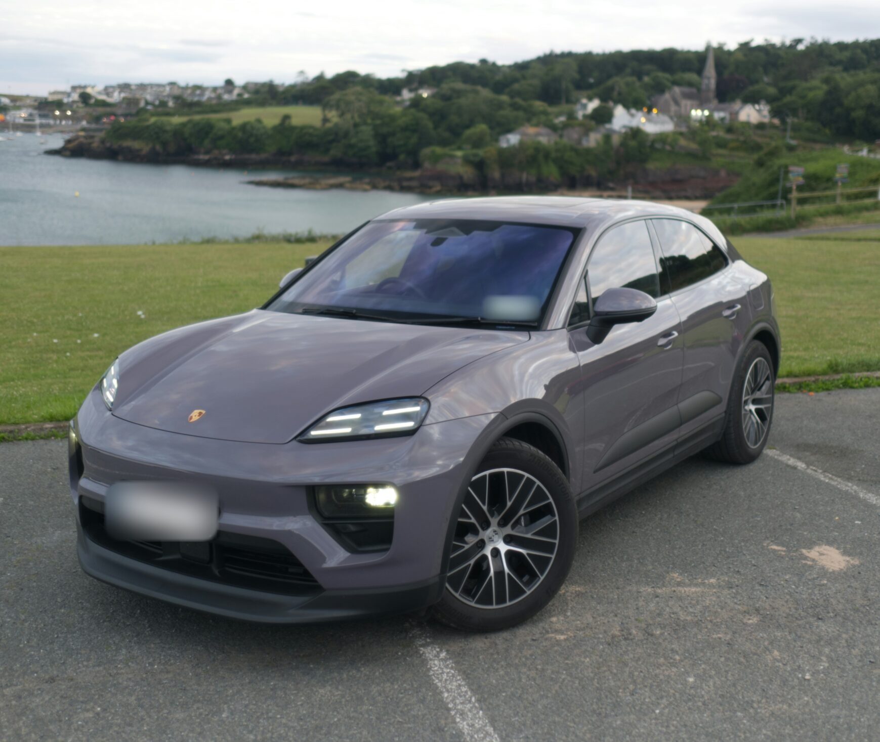 Porsche Macan 4 Electric grise au bord d’une baie