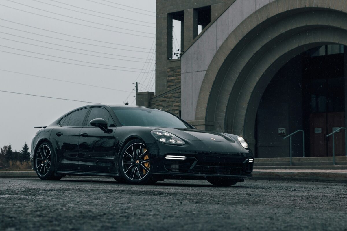 Porsche Panamera GTS noire devant une arche en pierre
