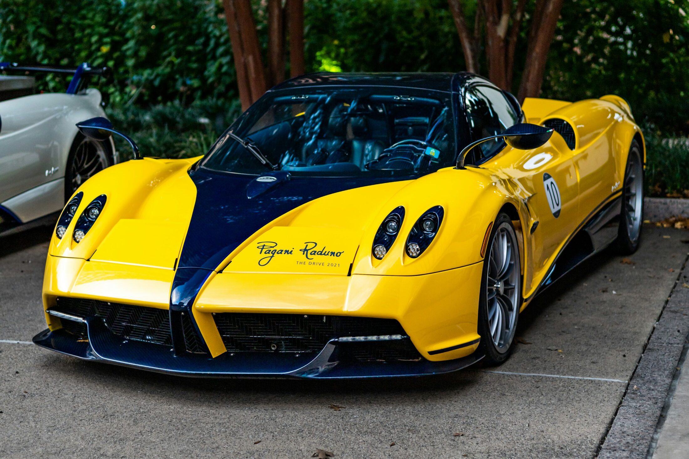 Pagani Huayra Roadster jaune et bleue sur un parking