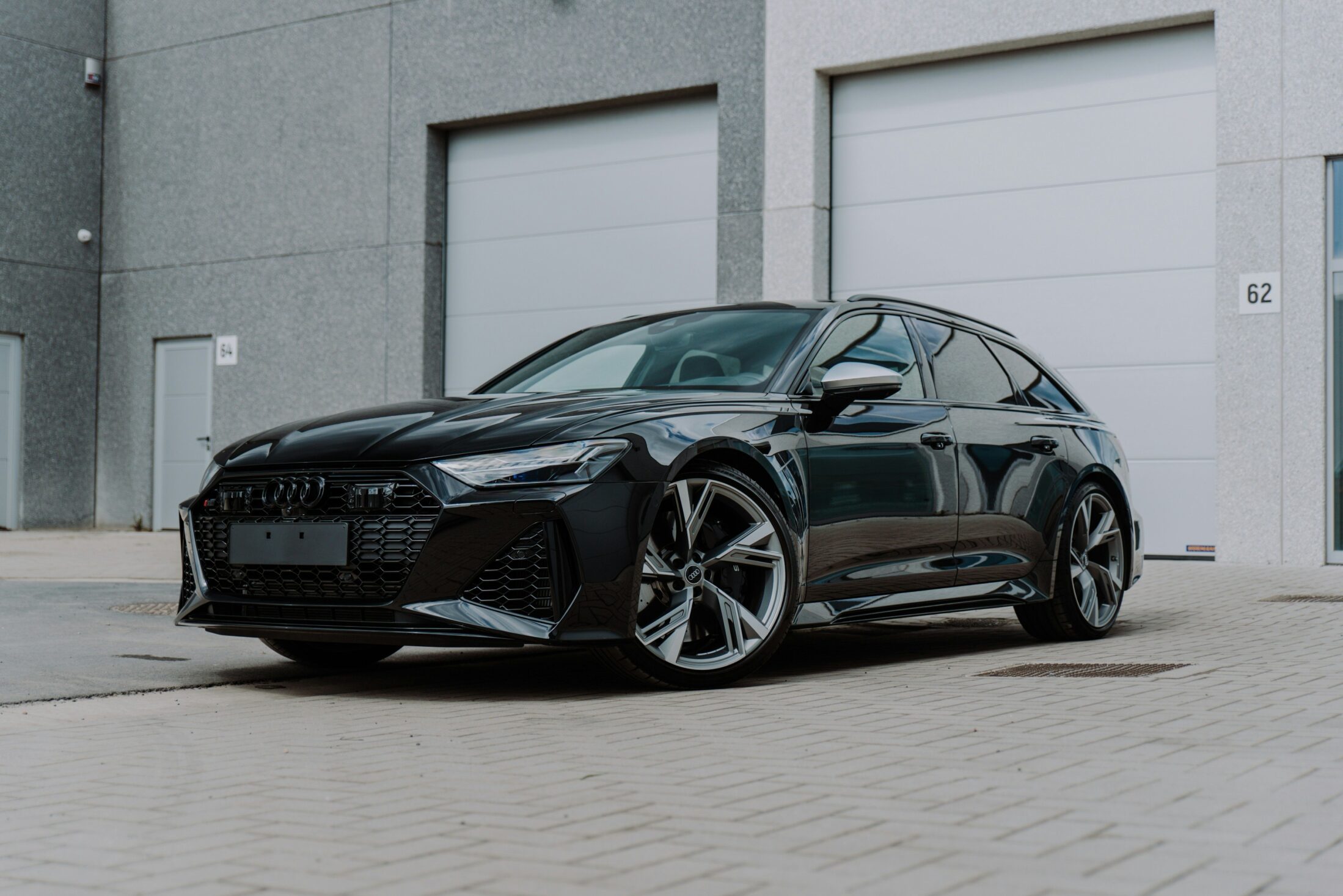 Audi RS 6 Avant noire devant des portes de garage