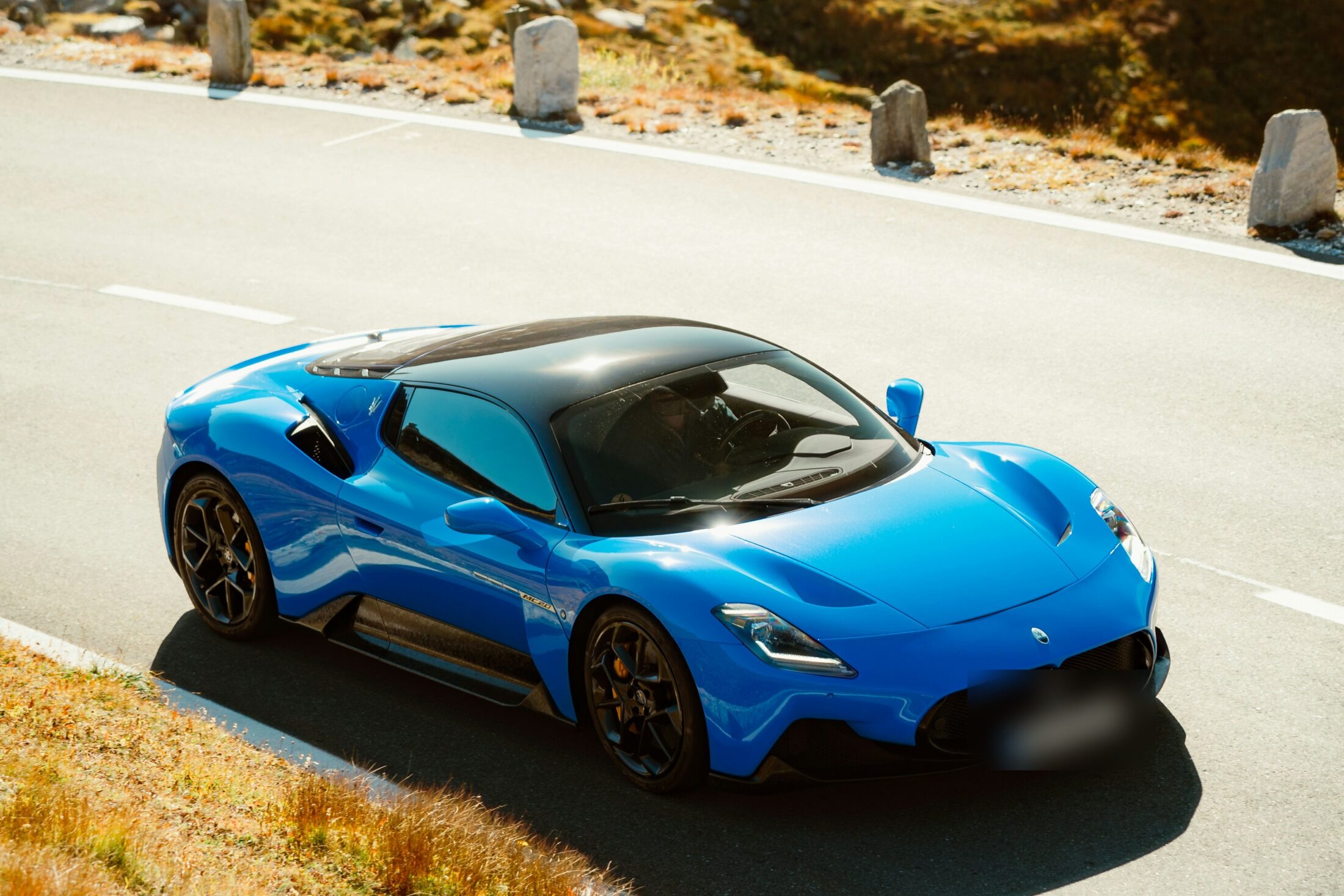 Maserati MC20 bleue sur une route de montagne (la MCPura en est l’évolution)