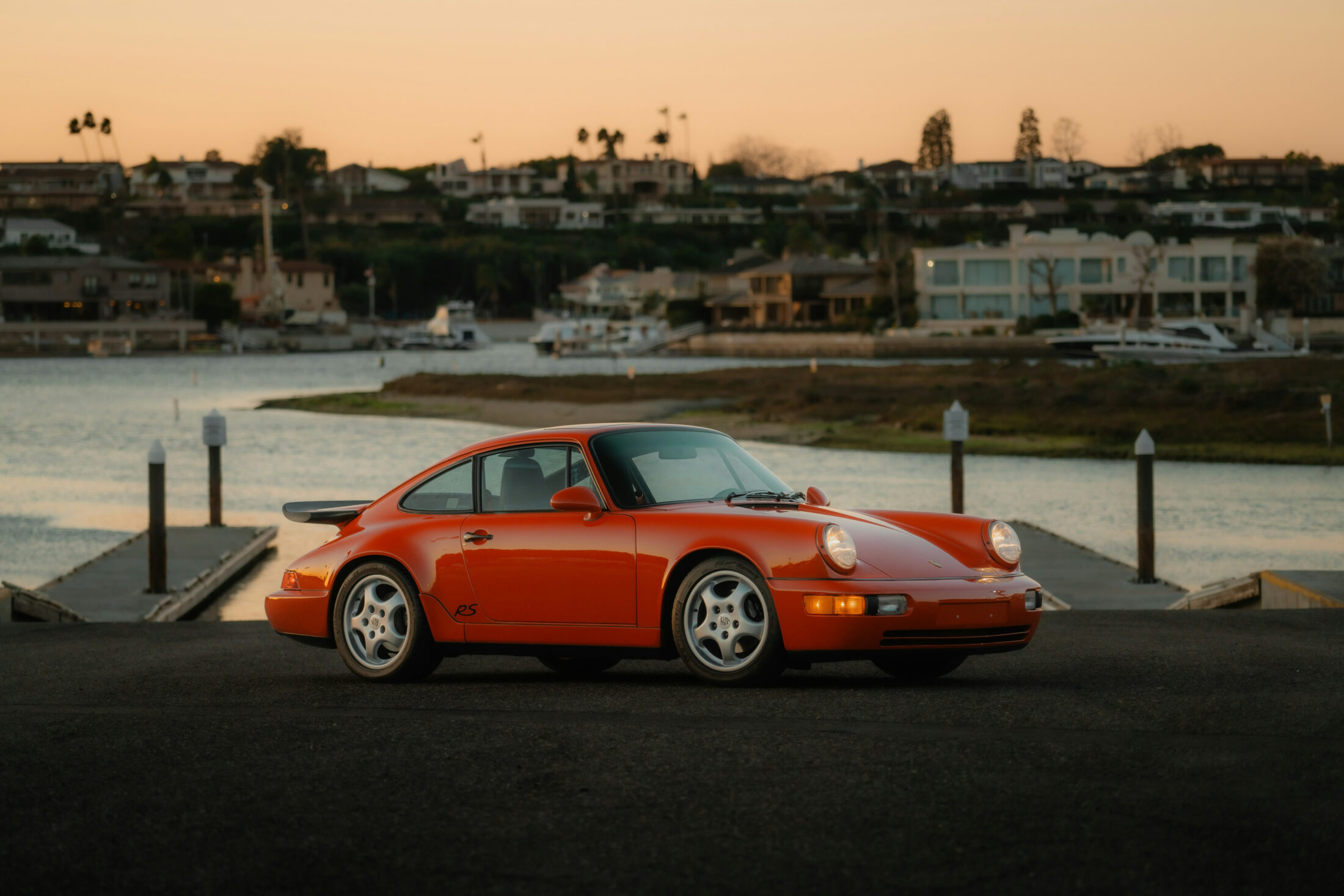 Porsche 911 Carrera RS America (964) orange au coucher du soleil
