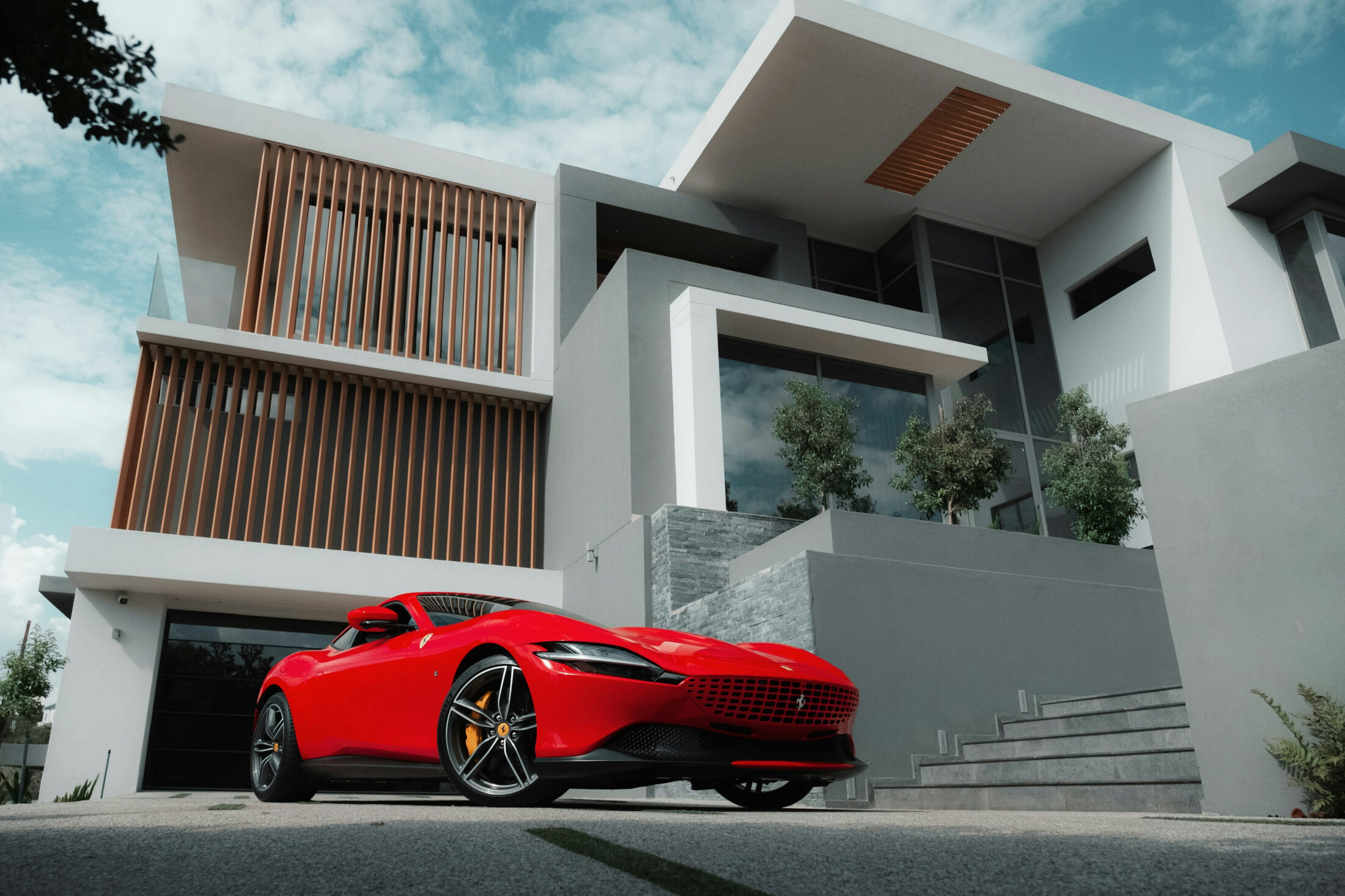 Ferrari Roma rouge devant une villa contemporaine