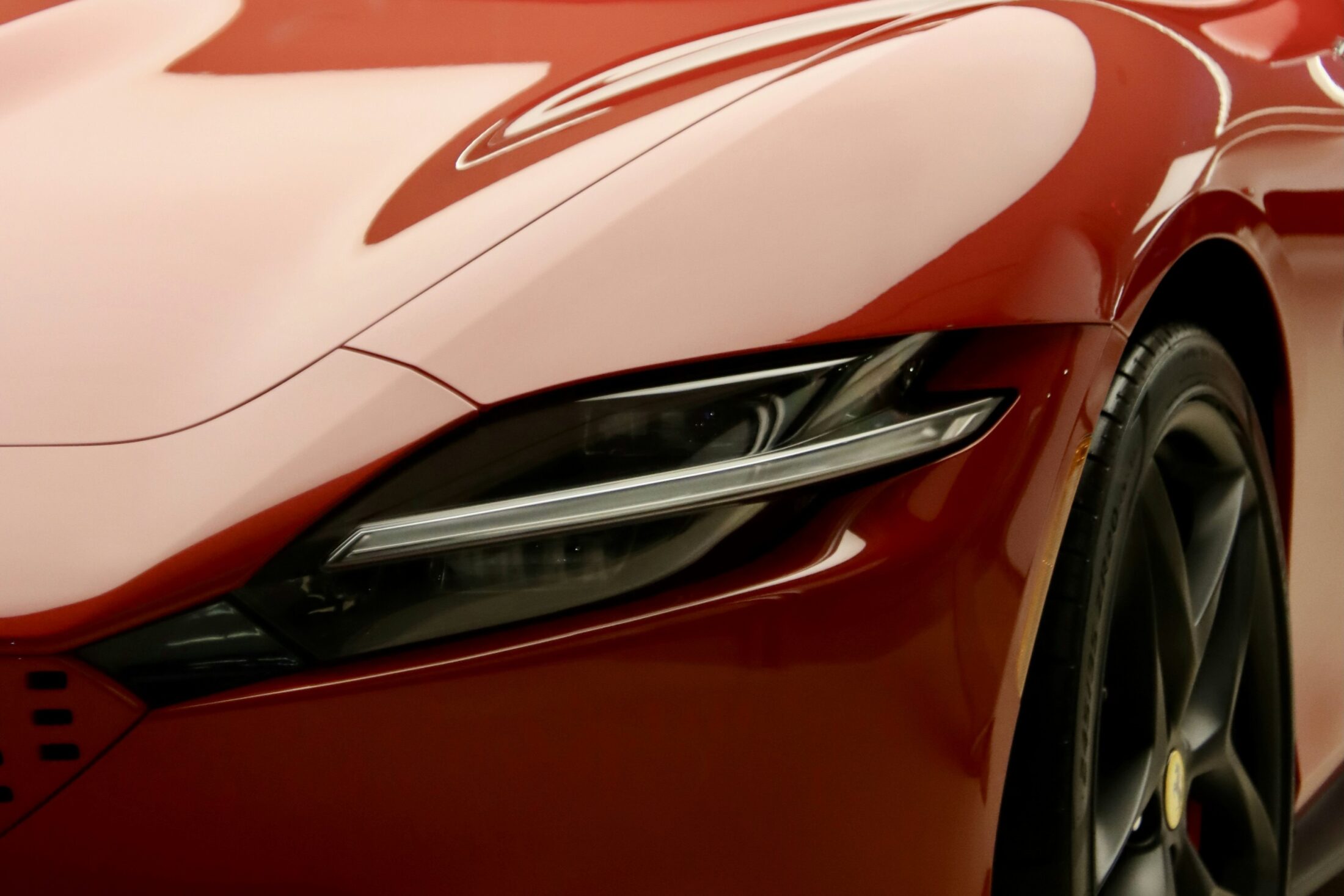 Ferrari Roma rouge en showroom, phare et capot