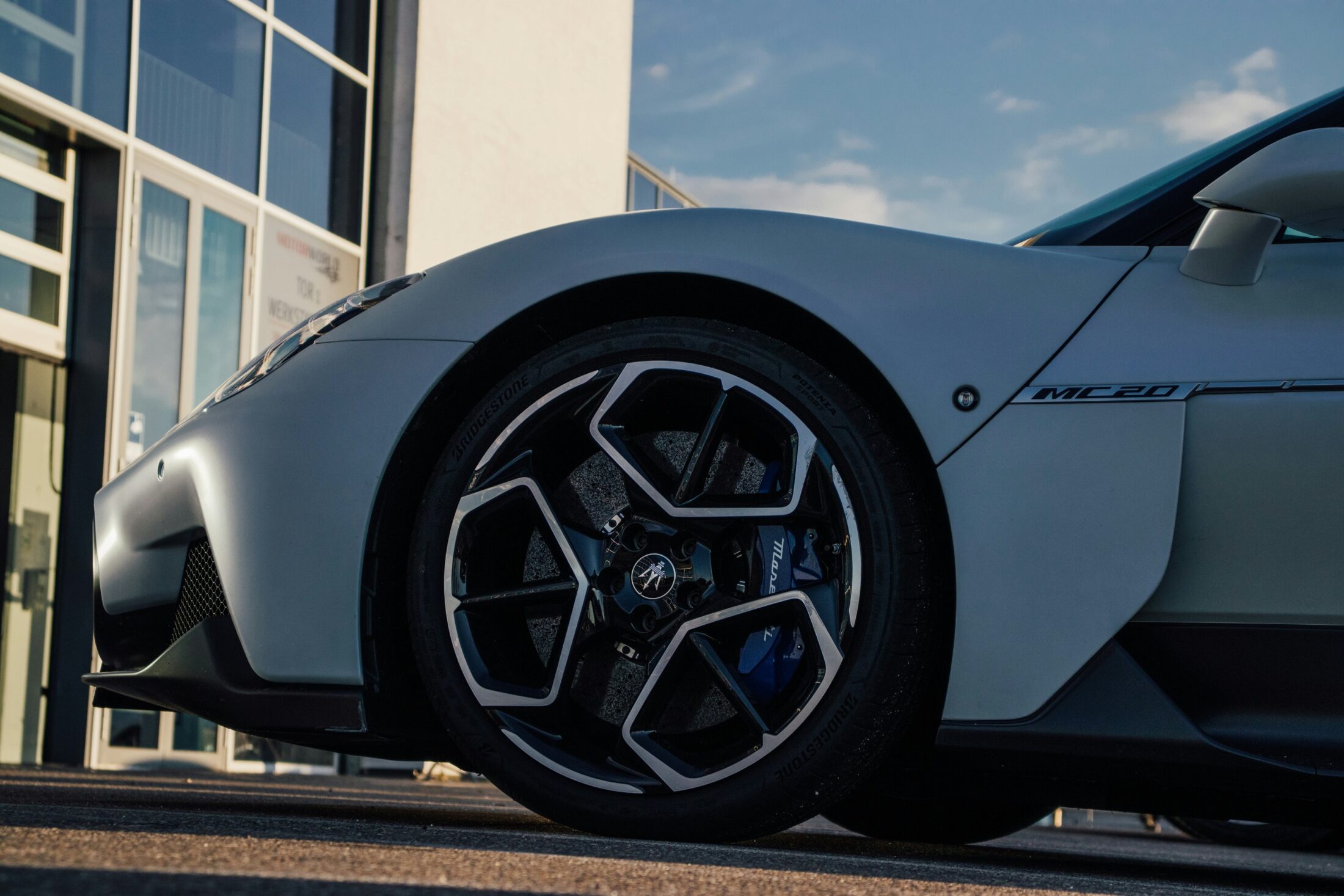 Maserati MC20 blanche, jante, étrier bleu et monogramme MC20