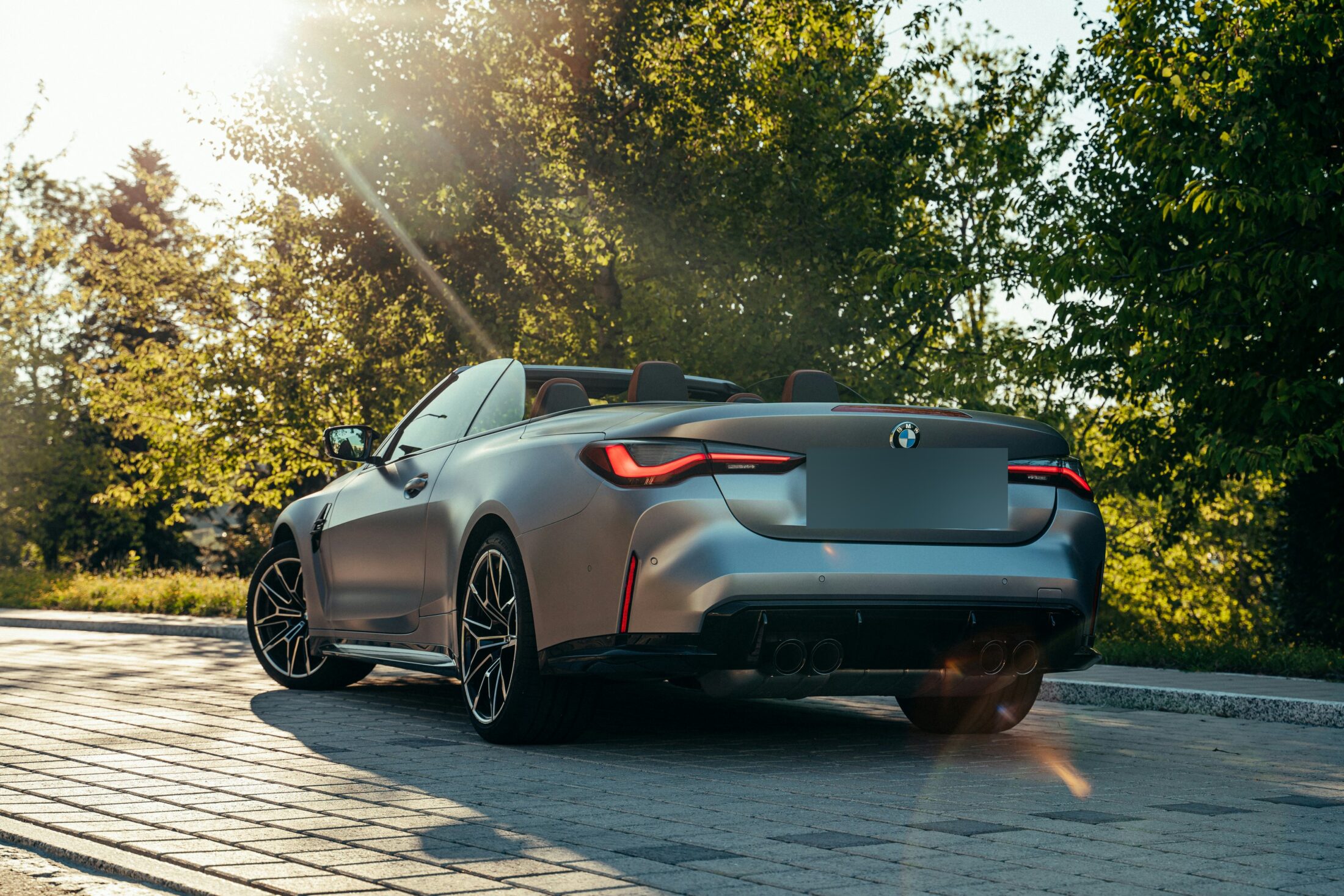 BMW M4 Competition Cabriolet grise, trois-quarts arrière, capote ouverte